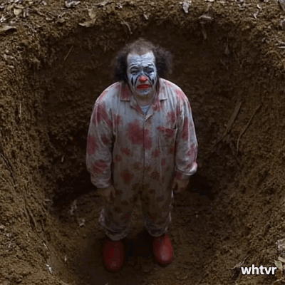 sad clown being buried alive in a grave